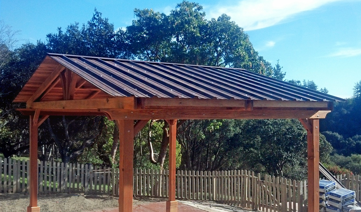 Del Norte Outdoor Kitchen Pavilion (Options: 18' L x 14' W, California Redwood, Unattached, 4-Post Anchor Kit for High-Wind, No Electrical Wiring Trim, 9.5 ft Post Height, No Ceiling Fan Base, No Privacy Panels, No Curtain Rods, Transparent Premium Sealant). Metal Roof by Custom Request. 