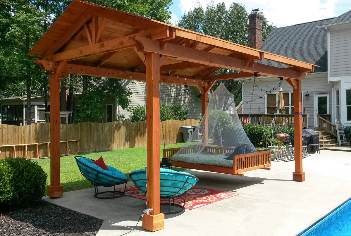 Del Norte Outdoor Kitchen Pavilion (Options: 18' L x 12' Triangle Base W, California Redwood, Unattached, 4-Post Anchor Kit for Concrete, No Electrical Wiring, 9 ft Post Height, No Ceiling Fan Bse, No Privacy Panels, 4 Curtain Rods,Transparent Sealant) with a Custom Day Bed. Photo Courtesy of Kym C. of Charlotte, NC.