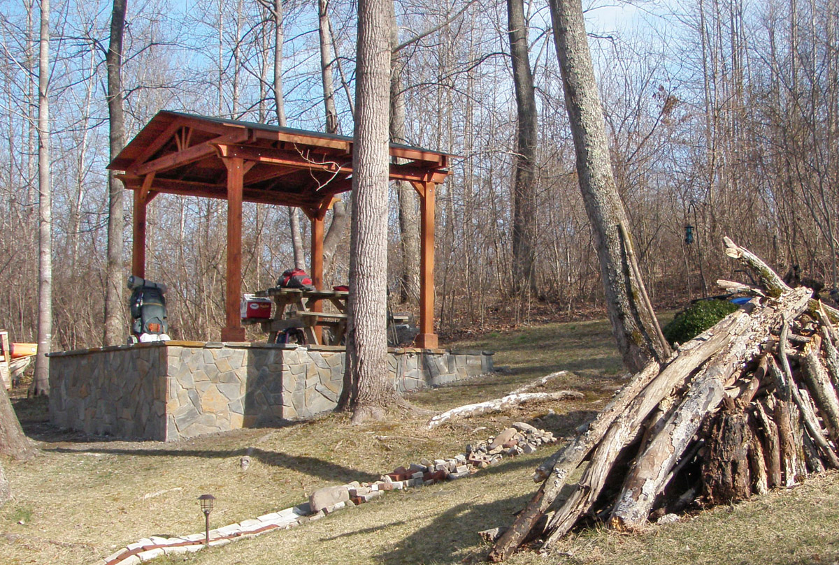 Del Norte Outdoor Kitchen Pavilion (Options: 12' L x 12' W, Mature Redwood, Unattached, 4-Post Anchor Kit for Stone, No Electrical Wiring Trim, 9' Posts, No Ceiling Fan Base, No Privacy Panels, No Curtain Rods, Transparent Premium Sealant). Photo Courtesy of Lisa K.  & Peter S. of Lexington, VA.