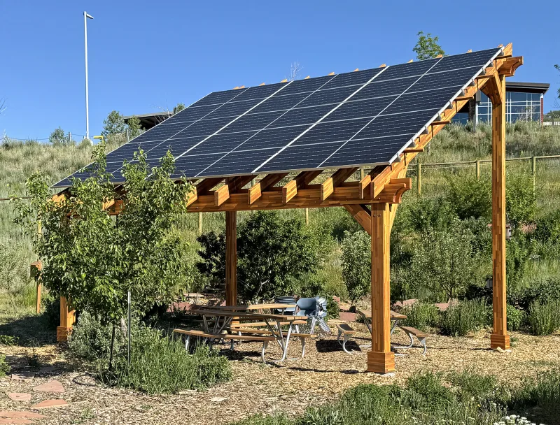 A redwood pergola with a solar panel roof