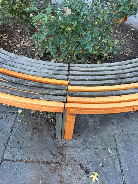 Where a new redwood section and new slats meet the old bench at a leg