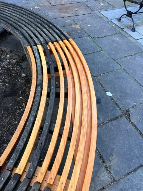 New curved redwood slats screwed in between the old weathered ones