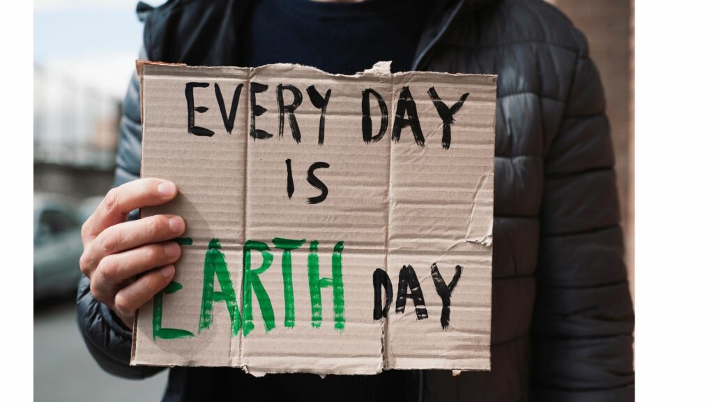 Person holding cardboard sign that reads, Every Day Is Earth Day