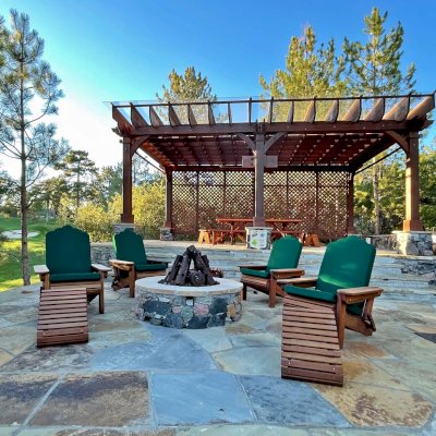 Adirondack Wooden Folding Chair (Options: Old-Growth Redwood, with Green Cushions, Standard Seat Depth, 2 Folding Adirondack Ottomans, Transparent Premium Sealant). Photo also shows a Montvale Pergola, and a Forever Picnic Table. Photo Courtesy of J. Brinkman of Castle Rock, Colorado.
