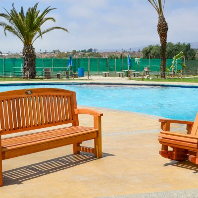 Adirondack Wooden Rocking Chair (Options: Standard Width, Douglas-fir, No Cushion, No Ottoman, Transparent Premium Sealant) and Luna Memorial Bench (Options: 5 ft, Douglas-fir, No Cushion, No Engraving, Custom Plaque Provided by Customer, Transparent Premium Sealant).