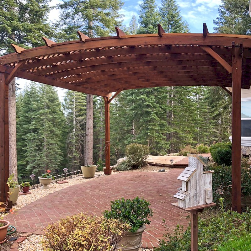 Arched Pergola Kits (Options: 20' L x 18' Arc W, Mature Redwood, Unattached, No Electrical Wiring Trim, Arched Roof with Lattice Panels, 4 Post Anchor Kit for Stone, No ceiling Fan Base, No Privacy Panels, No Curtain Rods, 10' Post Height, Transparent Premium Sealant). Photo Courtesy of Edward G. of Nevada City, CA. The original fotos for this pergola were from 2012. This photo was taken in Dec 2017 after the pergola was refinished by the Forever Redwood crew by request. Arched Pergola Kits (Options: 20' L x 18' Arc W, Mature Redwood, Unattached, No Electrical Wiring Trim, Arched Roof with Lattice Panels, 4 Post Anchor Kit for Stone, No ceiling Fan Base, No Privacy Panels, No Curtain Rods, 10' Post Height, Transparent Premium Sealant). Photo Courtesy of Edward G. of Nevada City, CA. The original fotos for this pergola were from 2012. This photo was taken in Dec 2017 after the pergola was refinished by the Forever Redwood crew by request.