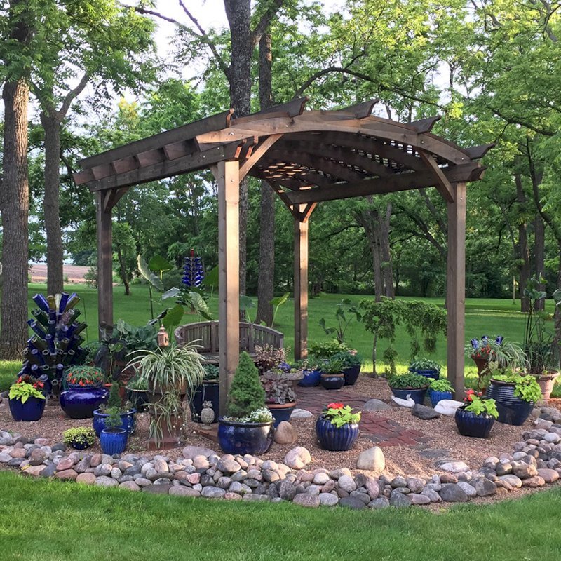 Arched Pergola Kits (Options: 12' L x 14' Arc W, California Redwood, Unattached, Electrical Wiring Trim for 1 Post, Arched Roof with Lattice Panels, 4 Post Anchor Kit for Concrete, No Ceiling Fan Base, No Privacy Panels, No Curtain Rods, 9' Post Height, Transparent Premium Sealant). Photo Also Shows a Jane's Key West Chair Under the Pergola. Photo Courtesy of Kay Taylor of Verona, Wisconsin. Arched Pergola Kits (Options: 12' L x 14' Arc W, California Redwood, Unattached, Electrical Wiring Trim for 1 Post, Arched Roof with Lattice Panels, 4 Post Anchor Kit for Concrete, No Ceiling Fan Base, No Privacy Panels, No Curtain Rods, 9' Post Height, Transparent Premium Sealant). Photo Also Shows a Jane's Key West Chair Under the Pergola. Photo Courtesy of Kay Taylor of Verona, Wisconsin.