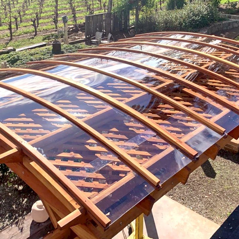 Arched Pergola Kit (Options: 14' L x 10' Arc W, California Redwood, No Electrical Wiring Trim Kit, 4 Post Anchor Kit for Concrete, No Ceiling Fan Base, No Privacy Panels, with Rain Guard, No Curtain Rods, 10.5' Post Height, Transparent Premium Sealant). Photo Courtesy of S. Taplin of St. Helena, CA. Arched Pergola Kit (Options: 14' L x 10' Arc W, California Redwood, No Electrical Wiring Trim Kit, 4 Post Anchor Kit for Concrete, No Ceiling Fan Base, No Privacy Panels, with Rain Guard, No Curtain Rods, 10.5' Post Height, Transparent Premium Sealant). Photo Courtesy of S. Taplin of St. Helena, CA.