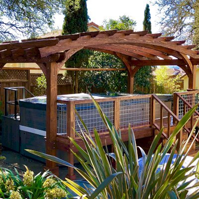 Custom Arched Pergola Kit (Options: 12' L x 22' Arc W, Douglas-fir, Electrical Wiring Trim Kit for 1 Post, 4-Post Anchor Kit for Stone, No Ceiling Fan Base, No Privacy Panels, No Curtain Rods, 9' Post Height, Coffee-Stain Premium Sealant) with Custom Deck and Stairs by Custom Request. Photo Courtesy of Steve & Heidi Jones of Windsor, CA.