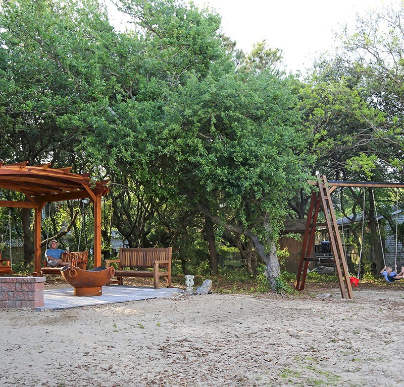 Arched Pergola Kits (Options: 12' L x 14' Arc W, California Redwood, Unattached, Electrical Wiring Trim for 1 Post, Arched Roof with Lattice Panels, 4 Post Anchor Kit for Gale-Wind, No Ceiling Fan Base, No Privacy Panels, No Curtain Rods, 9' Post Height, Transparent Premium Sealant). With 2 Bench Swings by Custom Request. Photo Also Shows a Rory's Swing Set and a Ti Amo Bench. Photo Courtesy of Tom Marten of Kitty Hawk, North Carolina. Arched Pergola Kits (Options: 12' L x 14' Arc W, California Redwood, Unattached, Electrical Wiring Trim for 1 Post, Arched Roof with Lattice Panels, 4 Post Anchor Kit for Gale-Wind, No Ceiling Fan Base, No Privacy Panels, No Curtain Rods, 9' Post Height, Transparent Premium Sealant). With 2 Bench Swings by Custom Request. Photo Also Shows a Rory's Swing Set and a Ti Amo Bench. Photo Courtesy of Tom Marten of Kitty Hawk, North Carolina.