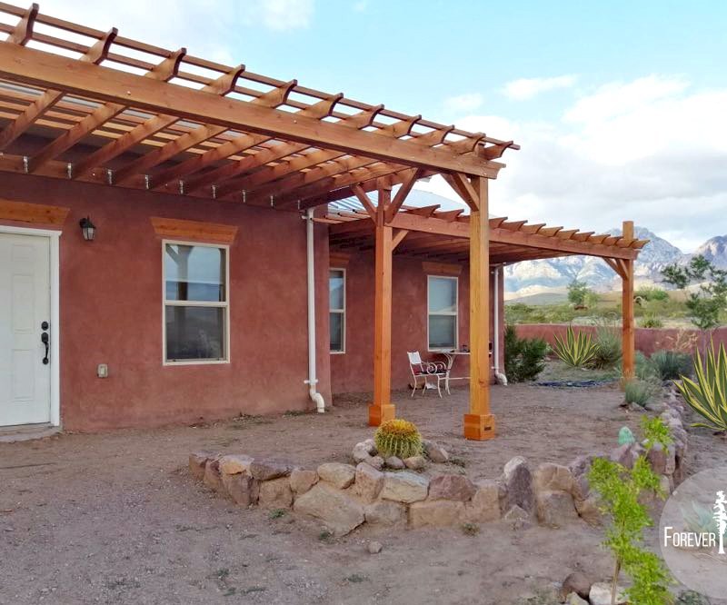 Attached Garden Pergolas (Options: 25' L x 12' W & 25' L x 7' W , Attached to Wall by Support Side, Douglas-fir, No Electrical Wiring Trim, Post Anchor Kit for Gale-Wind, Open Roof with Slats at 18", Rafters at 18", No Post Decorative Trims, Transparent Premium Sealant). Photo Courtesy of N. Miller of Las Cruces, New Mexico. Attached Garden Pergolas (Options: 25' L x 12' W & 25' L x 7' W , Attached to Wall by Support Side, Douglas-fir, No Electrical Wiring Trim, Post Anchor Kit for Gale-Wind, Open Roof with Slats at 18", Rafters at 18", No Post Decorative Trims, Transparent Premium Sealant). Photo Courtesy of N. Miller of Las Cruces, New Mexico.