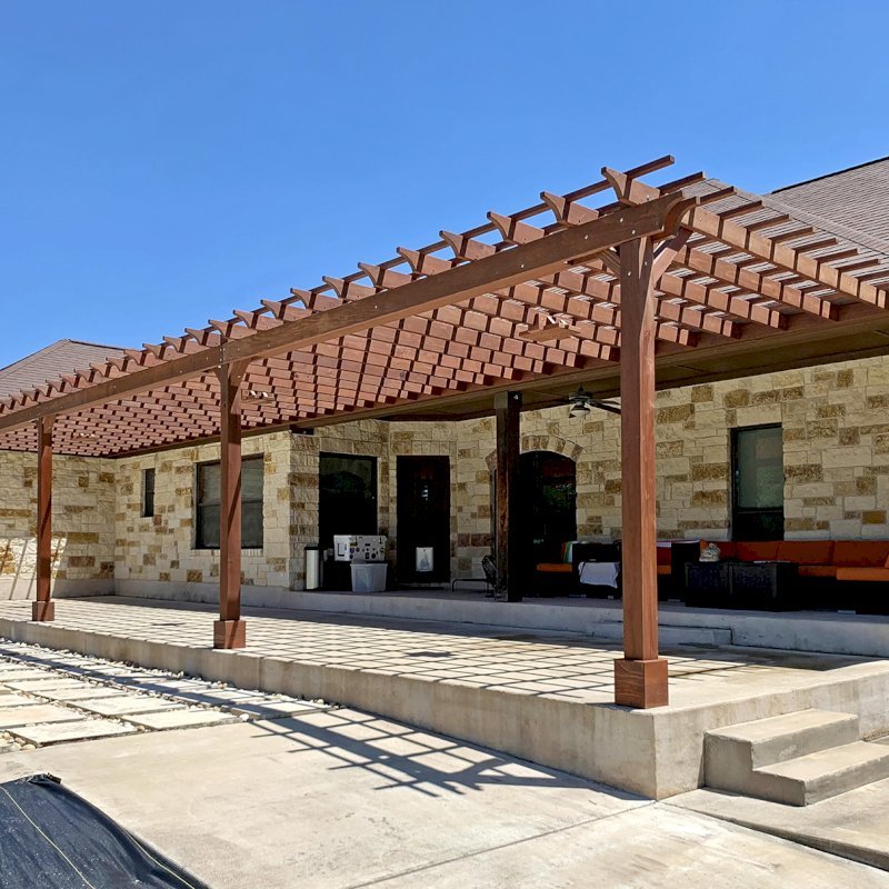 Custom Attached Garden Pergola (Options: 53' x 12', California Redwood, Open Roof with Slats at 12", Rafters at 18", 3-Post Anchor Kit for Concrete, 3 Ceiling Fan Bases, Coffee-Stain Premium Sealant). Ledger Board Attached to Wood House Fascia on 53' Side, and Steel Plate Used to Attach Dual Supports to Masonry House Wall. Photo Courtesy of S. Slawson of Buda, Texas. Custom Attached Garden Pergola (Options: 53' x 12', California Redwood, Open Roof with Slats at 12", Rafters at 18", 3-Post Anchor Kit for Concrete, 3 Ceiling Fan Bases, Coffee-Stain Premium Sealant). Ledger Board Attached to Wood House Fascia on 53' Side, and Steel Plate Used to Attach Dual Supports to Masonry House Wall. Photo Courtesy of S. Slawson of Buda, Texas.