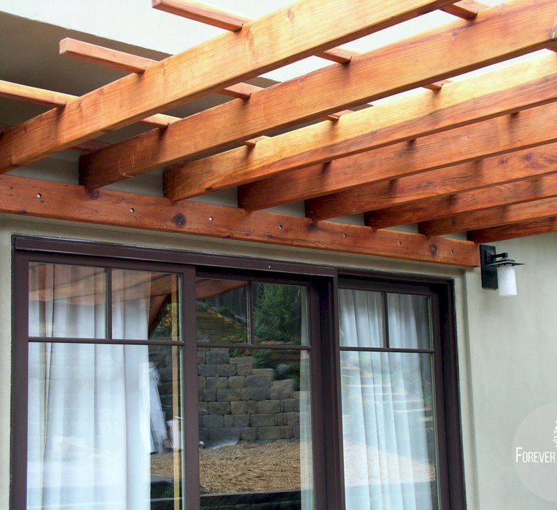 Attached Garden Pergolas (Options: 12' L x 12' W, Attached to Wall by Support Side, Mature Redwood, No Electrical Wiring Trim, Open Roof with Slats at 18", 2-Post Anchor Kit for Concrete, Transparent Premium Sealant). Attached Garden Pergolas (Options: 12' L x 12' W, Attached to Wall by Support Side, Mature Redwood, No Electrical Wiring Trim, Open Roof with Slats at 18", 2-Post Anchor Kit for Concrete, Transparent Premium Sealant).