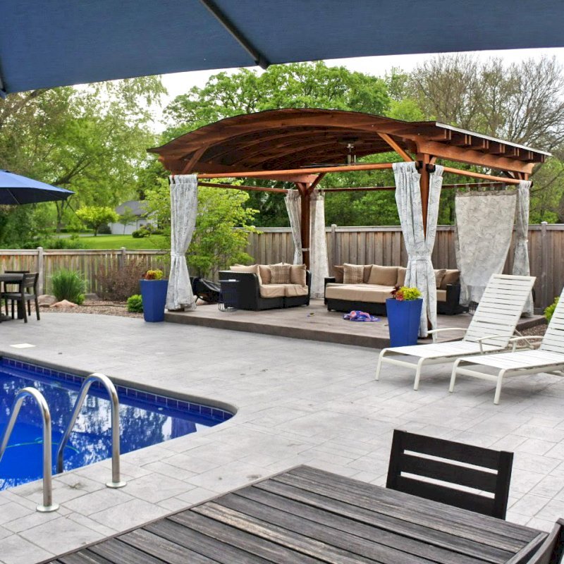 Backyard Pavilion Kits (Options: 15' L x 18' Arc W, California Redwood, 2 Post Electrical Wiring Trims, 4 Post Anchor Kit for Concrete, 1 Ceiling Fan Base, No Privacy Panels, 4 Curtain Rods, 9 ft Post Height, Transparent Premium Sealant). Photo Courtesy of S. McDonald of Lake Barrington, Illinois. Backyard Pavilion Kits (Options: 15' L x 18' Arc W, California Redwood, 2 Post Electrical Wiring Trims, 4 Post Anchor Kit for Concrete, 1 Ceiling Fan Base, No Privacy Panels, 4 Curtain Rods, 9 ft Post Height, Transparent Premium Sealant). Photo Courtesy of S. McDonald of Lake Barrington, Illinois.