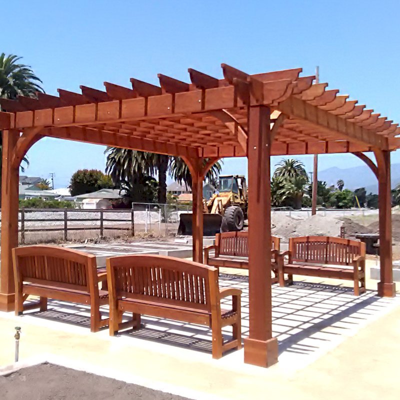 Cherry Hill Pergola (Options: 16' x 20', Mature Redwood, Post Anchoring for Concrete, No Ceiling Fan Base, No Curtain Rods, No Privacy Panels, 9.5' Post, Transparent Premium Sealant). 2 x 8 Roof Timbers and 8 x 8 Posts by Custom Request. Photo also shows 4 Luna Memorial Benches. Photos taken in Carpinteria Garden Park during construction, May 10, 2017. Photo Courtesy of M. Roberts of Carpinteria, CA. Cherry Hill Pergola (Options: 16' x 20', Mature Redwood, Post Anchoring for Concrete, No Ceiling Fan Base, No Curtain Rods, No Privacy Panels, 9.5' Post, Transparent Premium Sealant). 2 x 8 Roof Timbers and 8 x 8 Posts by Custom Request. Photo also shows 4 Luna Memorial Benches. Photos taken in Carpinteria Garden Park during construction, May 10, 2017. Photo Courtesy of M. Roberts of Carpinteria, CA.