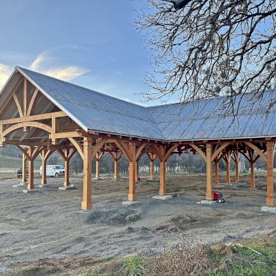 Custom Wood Pavilion (Options: 74' x 74', Douglas-fir, 20-Post Anchor Kit for High-Wind, 10' H Posts, Horizontal Decorative Trims for All Posts, with 5 Ceiling Fan Bases, Transparent Premium Sealant, White Wash for Ceiling). Photo Courtesy of J. Fookes of Elk Creek, CA.