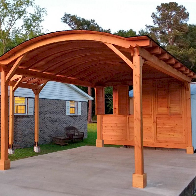 Custom Wood Pavilion Kits (Options: 20' L, 14' W, 1 Shutter Privacy Panel, Douglas-fir, No Electrical Wiring Trim, 2 Post Anchor Kit for Concrete, No Ceiling Fan Base, No Curtain Rods, 9.5' Post Height, Transparent Premium Sealant) with an Attached Arched Pergola on the Left. Photo Courtesy of E.West of Pine Hill, AL. Custom Wood Pavilion Kits (Options: 20' L, 14' W, 1 Shutter Privacy Panel, Douglas-fir, No Electrical Wiring Trim, 2 Post Anchor Kit for Concrete, No Ceiling Fan Base, No Curtain Rods, 9.5' Post Height, Transparent Premium Sealant) with an Attached Arched Pergola on the Left. Photo Courtesy of E.West of Pine Hill, AL.