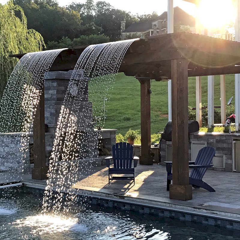Custom Garden Pergola (Options: 16' L x 16' W, California Redwood, 4-Post Anchor Kit for Concrete, Cherry Stain Premium Sealant). Plumbing was built into the timbers to create a waterfall. Photo Courtesy of D. Hogan of Charlottesville, Virginia. Custom Garden Pergola (Options: 16' L x 16' W, California Redwood, 4-Post Anchor Kit for Concrete, Cherry Stain Premium Sealant). Plumbing was built into the timbers to create a waterfall. Photo Courtesy of D. Hogan of Charlottesville, Virginia.