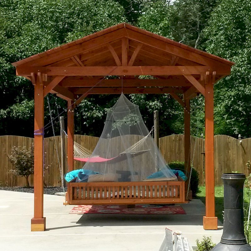 Del Norte Outdoor Kitchen Pavilion (Options: 18' L x 12' Triangle Base W, California Redwood, Unattached, 4 Post Anchor Kit for Stone, Brick or Concrete, No Electrical Wiring, 9 ft Post Height, No Ceiling Fan Bse, No Privacy Panels, 4 Curtain Rods,Transparent Sealant) with a Custom Day Bed. Photo Courtesy of Kym C. of Charlotte, NC. Del Norte Outdoor Kitchen Pavilion (Options: 18' L x 12' Triangle Base W, California Redwood, Unattached, 4 Post Anchor Kit for Stone, Brick or Concrete, No Electrical Wiring, 9 ft Post Height, No Ceiling Fan Bse, No Privacy Panels, 4 Curtain Rods,Transparent Sealant) with a Custom Day Bed. Photo Courtesy of Kym C. of Charlotte, NC.