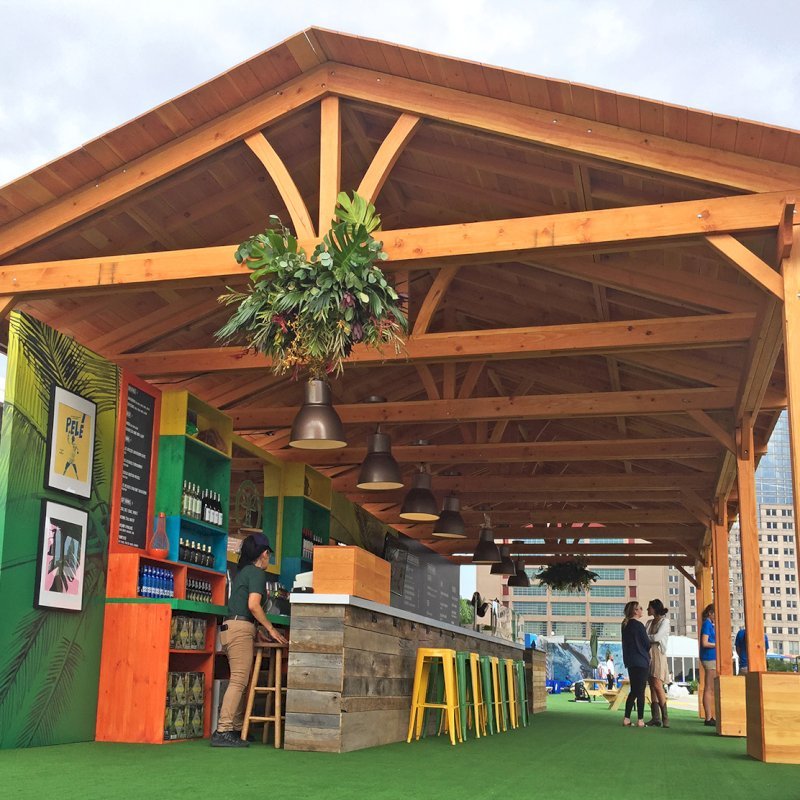 Rio on the Hudson: Olympic Village in NYC. 2 Del Norte Outdoor Kitchen Pavilions (Options: 25' L x 20' W, Douglas-fir, We used 2' x 2' x 2' Concrete Blocks to Anchor the Structure Because it is a Temporary Installation, Covered the Concrete Blocks with Wooden Boxes, No Ceiling Fan Base, Transparent Premium Sealant). Photo Courtesy of A. Fisher of New York, NY. Rio on the Hudson: Olympic Village in NYC. 2 Del Norte Outdoor Kitchen Pavilions (Options: 25' L x 20' W, Douglas-fir, We used 2' x 2' x 2' Concrete Blocks to Anchor the Structure Because it is a Temporary Installation, Covered the Concrete Blocks with Wooden Boxes, No Ceiling Fan Base, Transparent Premium Sealant). Photo Courtesy of A. Fisher of New York, NY.