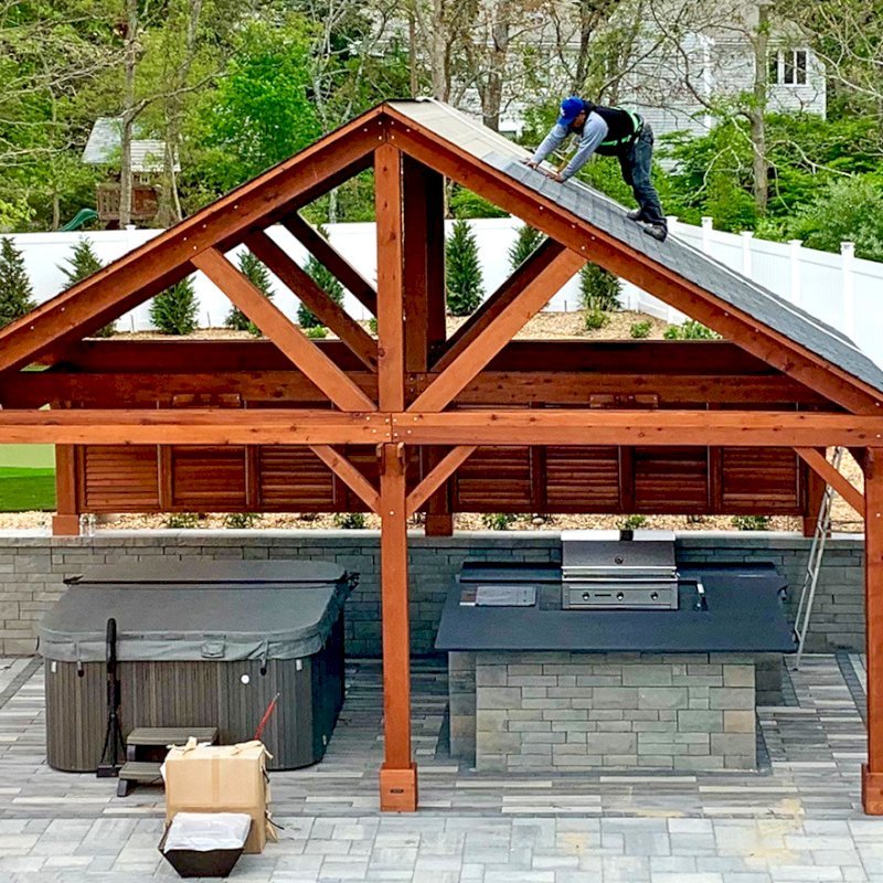Del Rio Cathedral Ceiling Thick Timber Pavilion (Options: 18' L x 26' W, California Redwood, 6-Post Kit for Concrete, Electrical Wiring Trim for 2 Posts, 9.5' Posts, 2 Ceiling Fan Bases, No Privacy Panels, No Curtain Rods, Transparent Premium Sealant, with Extra Knee Braces on the Back by Custom Request). Photo Courtesy of B. Poutre of North Falmouth, Massachusetts. Del Rio Cathedral Ceiling Thick Timber Pavilion (Options: 18' L x 26' W, California Redwood, 6-Post Kit for Concrete, Electrical Wiring Trim for 2 Posts, 9.5' Posts, 2 Ceiling Fan Bases, No Privacy Panels, No Curtain Rods, Transparent Premium Sealant, with Extra Knee Braces on the Back by Custom Request). Photo Courtesy of B. Poutre of North Falmouth, Massachusetts.