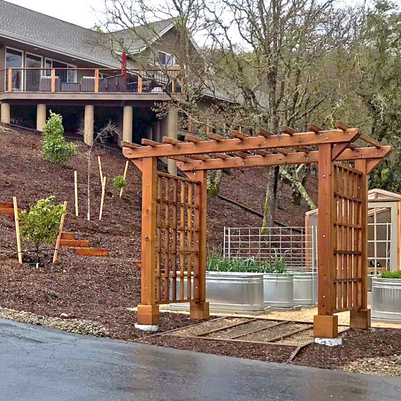 Custom Entryway Arbor (Options: 120" W, 84" D, California Redwood, 4-Post Archor Kit for Concrete, Transparent Premium Sealant) with 6 x 6 Posts and 2 x 6 Rafters by Custom Request. Photo Courtesy of K. Moore of Healdsburg, CA. Custom Entryway Arbor (Options: 120" W, 84" D, California Redwood, 4-Post Archor Kit for Concrete, Transparent Premium Sealant) with 6 x 6 Posts and 2 x 6 Rafters by Custom Request. Photo Courtesy of K. Moore of Healdsburg, CA.