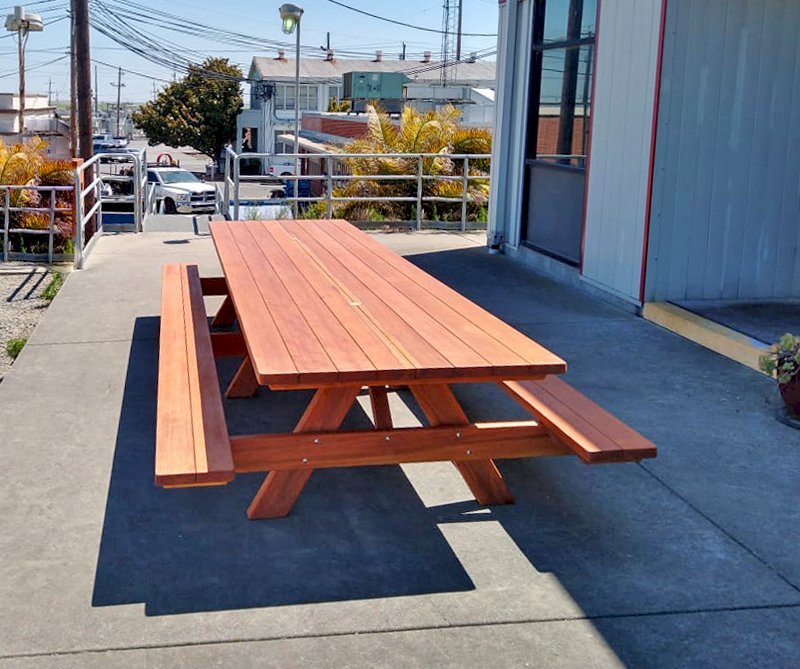 Custom Forever Picnic Tables (Attached Benches) (Options: 14' L x 48" W, California Redwood, Standard Tabletop, 2 Umbrella Holes, Slightly Rounded Corners, Transparent Premium Sealant). Photo Courtesy of E. Lagare of Martinez, CA. Custom Forever Picnic Tables (Attached Benches) (Options: 14' L x 48" W, California Redwood, Standard Tabletop, 2 Umbrella Holes, Slightly Rounded Corners, Transparent Premium Sealant). Photo Courtesy of E. Lagare of Martinez, CA.
