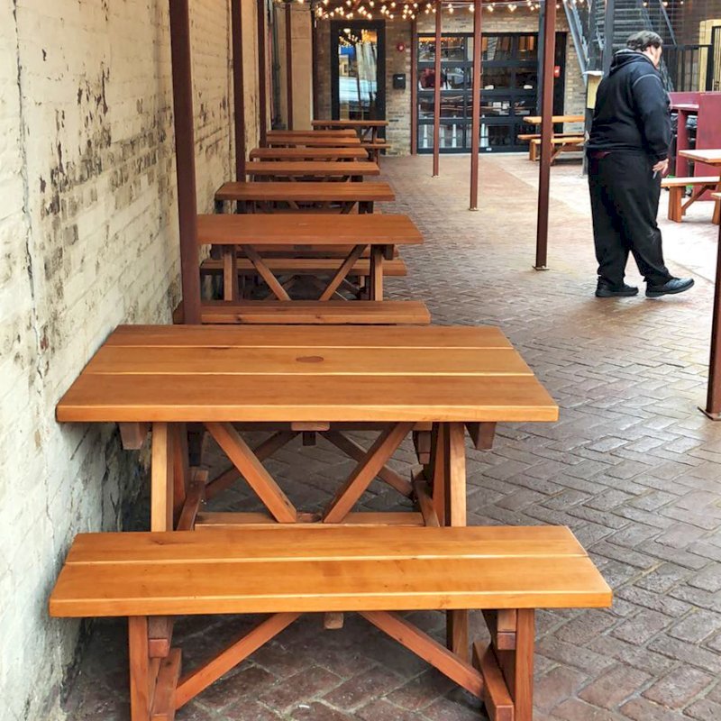 Forever Picnic Tables (Unattached Benches) (Options: 4', 34 1/2" W, Side Benches, Mature Redwood, 1 Full Length Side Bench Per Side, Standard Tabletop, Squared Corners, 2" Umbrella Hole, Transparent Premium Sealant). Standard design is with 5 3/4" wide boards. The tabletops in this photo were built for the restaurant by request using bookend construction (where 2 standard width 5 3/4" wide boards are tongue and grooved together to appear as one wider 11 1/2" wide board). If you would like this effect for your tables, just add a note saying want bookend detail added to your order (no extra charge to do this). Photo courtesy of M. Piekarz of Chicago, IL. Forever Picnic Tables (Unattached Benches) (Options: 4', 34 1/2" W, Side Benches, Mature Redwood, 1 Full Length Side Bench Per Side, Standard Tabletop, Squared Corners, 2" Umbrella Hole, Transparent Premium Sealant). Standard design is with 5 3/4" wide boards. The tabletops in this photo were built for the restaurant by request using bookend construction (where 2 standard width 5 3/4" wide boards are tongue and grooved together to appear as one wider 11 1/2" wide board). If you would like this effect for your tables, just add a note saying want bookend detail added to your order (no extra charge to do this). Photo courtesy of M. Piekarz of Chicago, IL.