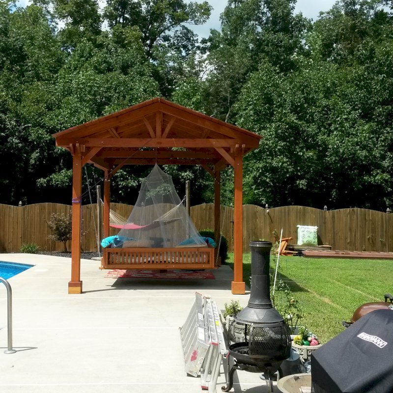 Jhoola Day Bed Swing Sets (Options: 7' L, 60" W, Seat Only, California Redwood, All Beam Hanging Hardware, Add 3 Railings (North, South and extra one, East or West), Day Bed Style, No Cushion, Transparent Premium Sealant). Also shows a Del Norte Pavilion. Jhoola Day Bed Swing Sets (Options: 7' L, 60" W, Seat Only, California Redwood, All Beam Hanging Hardware, Add 3 Railings (North, South and extra one, East or West), Day Bed Style, No Cushion, Transparent Premium Sealant). Also shows a Del Norte Pavilion.