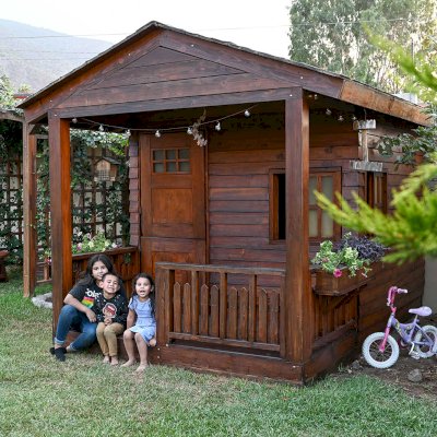 Kid's Backyard Cabin (Options: 12ft L x 8ft W, 7ft Wall H, Douglas-Fir, 4ft Front Porch Size [Included in the Overall Length], Interior Decking, Transparent Premium Sealant). Photo shows structure recently resealed after 6 years of loving service.