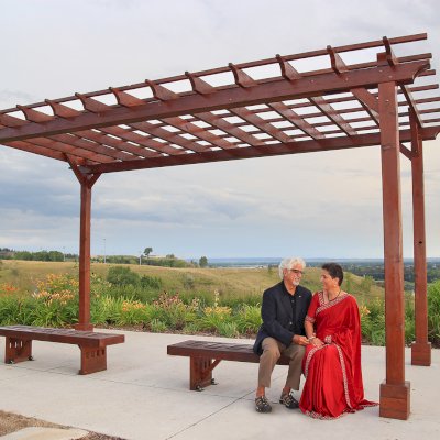 Lighthouse Garden Benches (Options: 4.5 ft L x 17 3/4 inches W x 17 inches H, California Redwood, No Cushion, No Engraving, Coffee-Stain Premium Sealant). Benches Under a Traditional Garden Pergola. Photo Courtesy of Vinod & Aruna.