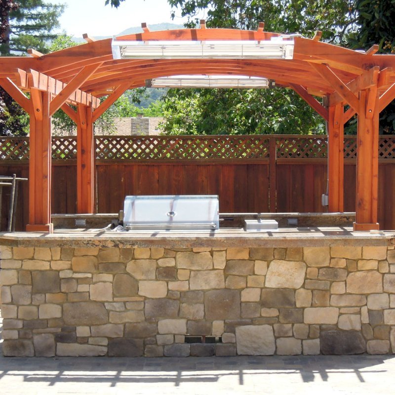 Marin Outdoor Kitchen Pergola (Options: 14' L x 16' Arc W, California Redwood, Unattached, 2 Post Electrical Wiring Trim, Arched Roof without Lattice Panels, 4 Post Anchor Kit for Stone, No Ceiling Fan Base, No Privacy, No Curtain Rods, 9 ft Post Height (front posts wrapped with masonry), Transparent Premium Sealant). Marin Outdoor Kitchen Pergola (Options: 14' L x 16' Arc W, California Redwood, Unattached, 2 Post Electrical Wiring Trim, Arched Roof without Lattice Panels, 4 Post Anchor Kit for Stone, No Ceiling Fan Base, No Privacy, No Curtain Rods, 9 ft Post Height (front posts wrapped with masonry), Transparent Premium Sealant).