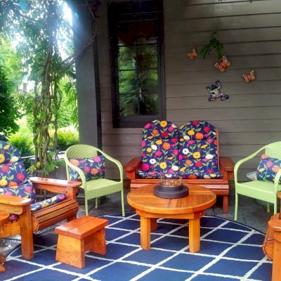 Mini 12 Inch Round Wood Side Table (Options: California Redwood, 18 inches Tall, Transparent Premium Sealant). Photo also shows Round Terrace Table, a Small Wooden Foot Stool, 2 Adirondack Folding Chairs and an Adirondack Loveseat. Photo Courtesy of Deborah O'Toole of Midlothian, Virginia.