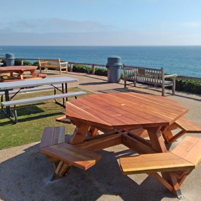 Octagonal Picnic Tables (Options: 5 1/2' Diameter Tabletop, Attached Benches, California Redwood, Standard Tabletop, 1 5/8" Umbrella Hole, Transparent Premium Sealant). Photo Courtesy of G. Cooley of Dana Point, CA. Plastic gray tables not made by Forever Redwood!