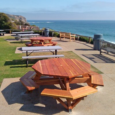 Octagonal Picnic Tables (Options: 5 1/2' Diameter Tabletop, Attached Benches, California Redwood, Standard Tabletop, 1 5/8" Umbrella Hole, Transparent Premium Sealant). Photo Courtesy of G. Cooley of Dana Point, CA. Plastic gray tables not made by Forever Redwood!