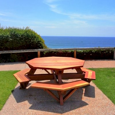 Octagonal Picnic Table (Options: 5.5' Diameter Tabletop, Attached Benches, California Redwood, Standard Tabletop, Rounded Corners, 1 5/8" Diameter Umbrella Hole, Transparent Premium Sealant). Photo Courtesy of C. Cooley of Dana Point, CA.