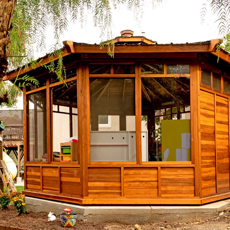 Octagonal Sunroom Gazebo (Options: 16' Diameter, Internal Deck, California Redwood, 24" H Siding Below Windows, 4 Standard Window Panels & 3 Custom Panels, Clear Acrylic, 1 Ceiling Fan Base, 1 Set of Doors, Transparent Premium Sealant). Photo Courtesy of D. Coons of Morgan Hill, California. Octagonal Sunroom Gazebo (Options: 16' Diameter, Internal Deck, California Redwood, 24" H Siding Below Windows, 4 Standard Window Panels & 3 Custom Panels, Clear Acrylic, 1 Ceiling Fan Base, 1 Set of Doors, Transparent Premium Sealant). Photo Courtesy of D. Coons of Morgan Hill, California.