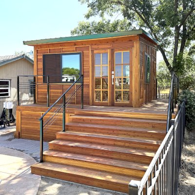 Custom Palo Alto Backyard Cabin (Options: 18' L, 16' W, With 19' x 19' Structural Deck with Steps, California Redwood for Exterior Finished, Douglas-fir Internal Walls and Framing, Double Door, Slidding Windows, Windows Purchased Locally, With Two 2' x 2' Skylights, Metal Roof, Electrical Wire Trim on the Walls, Transparent Premium Sealant). Photo Courtesy of R. & M. Hegwood of Ceres, CA.
