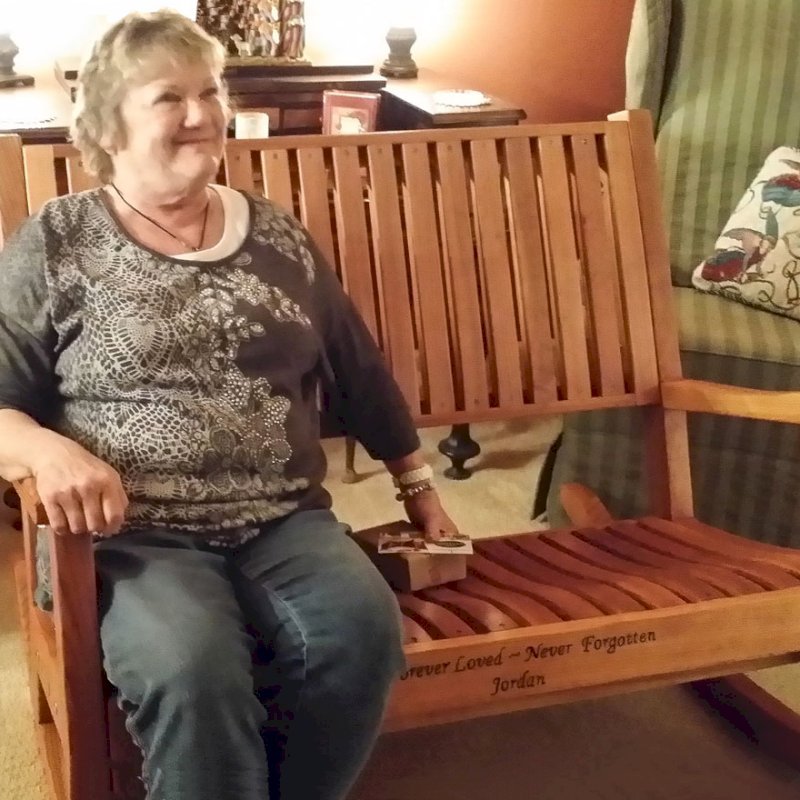 Ruth Redwood Rocking Bench (Options: Deep, Redwood, No Cushion, Custom Engraving, Transparent Premium Sealant). Photo Courtesy of Terri Stewart of Olathe, Kansas. Ruth Redwood Rocking Bench (Options: Deep, Redwood, No Cushion, Custom Engraving, Transparent Premium Sealant). Photo Courtesy of Terri Stewart of Olathe, Kansas.