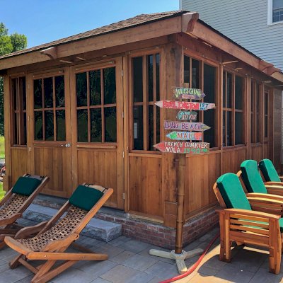 Spa Gazebo Kit (Options: 20' L, 14' W, Mature Redwood, All Sliding Windows, Without Skylight, Custom Roof, 36" H Siding Below Windows, Vertical Siding, Custom French Door without Screens, No Flooring, Transparent Premium Sealant). Photo Also Shows 2 Rio Hammock Chairs and 3 Reclining Redwood Easy Chairs. Photo Taken 18 Months After Installation. Photo Courtesy of J. Zawalski of Groveland, Massachusetts.