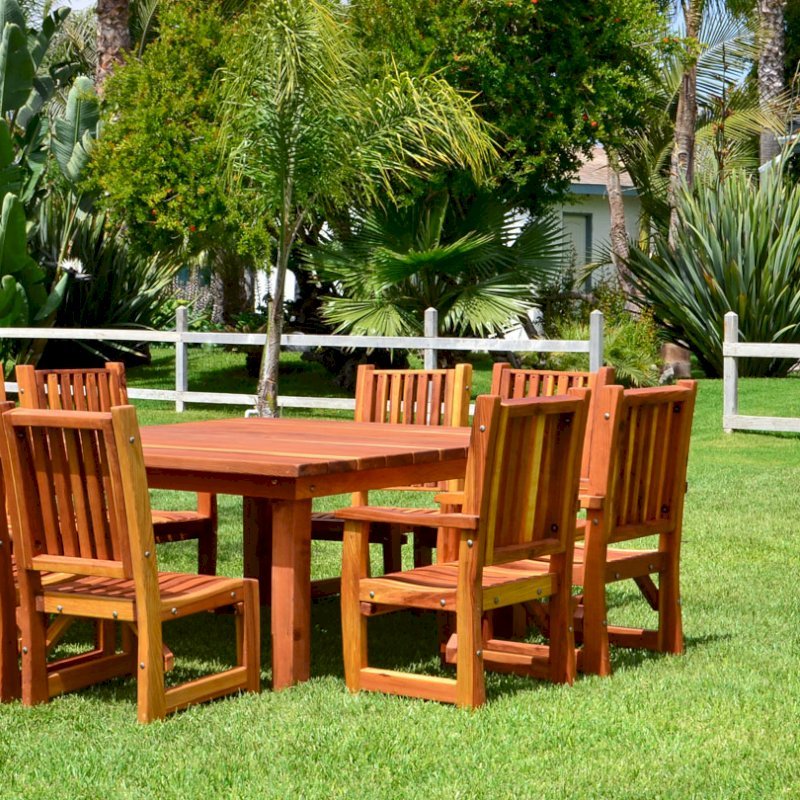 Square Patio Table (Options: 5.5', 8 Chairs, Redwood, Ruth Chairs, Combination of Armchairs and Side Chairs, No Cushions, Standard Tabletop, Slightly Rounded Corners, Umbrella Hole, Transparent Premium Sealant). Photo also shows a Wishing Wells in background. Square Patio Table (Options: 5.5', 8 Chairs, Redwood, Ruth Chairs, Combination of Armchairs and Side Chairs, No Cushions, Standard Tabletop, Slightly Rounded Corners, Umbrella Hole, Transparent Premium Sealant). Photo also shows a Wishing Wells in background.