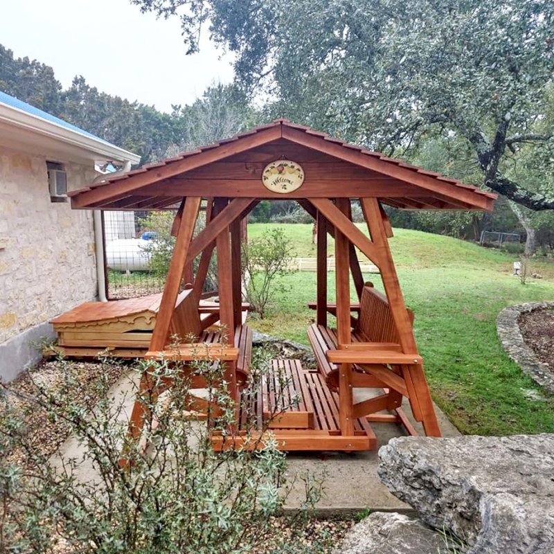 St. Anthony's Face to Face Gliders (Options: Extra Wide Size, Mature Redwood, With Beverage Armrests, No Kid's Platform, XW Roof, No Engraving, Transparent Premium Sealant). Photo Courtesy of R. Vincent of Wimberly, Texas. St. Anthony's Face to Face Gliders (Options: Extra Wide Size, Mature Redwood, With Beverage Armrests, No Kid's Platform, XW Roof, No Engraving, Transparent Premium Sealant). Photo Courtesy of R. Vincent of Wimberly, Texas.