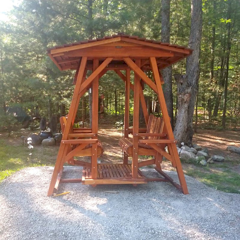 St. Anthony's Face to Face Gliders (Adult Size, Redwood, With Beverage Armrests, No Kid's Platform, Extra Wide Roof, No Engraving, Transparent Premium Sealant). Photo Courtesy of D. Jones of Lachine, Michigan. St. Anthony's Face to Face Gliders (Adult Size, Redwood, With Beverage Armrests, No Kid's Platform, Extra Wide Roof, No Engraving, Transparent Premium Sealant). Photo Courtesy of D. Jones of Lachine, Michigan.