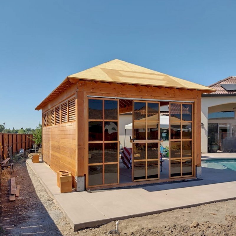 Custom Sun Gazebo with Sliding Doors (Options: 24' L x 16' W, Douglas-fir, with 1 Custom Solid Wall, 1 Side with Sliding Doors and 2 Open Sides, 9 ft Wall Height, Without Skylight, No Floor, Custom Roof, Transparent Premium Sealant). Photo Taken During Installation. Photo Courtesy of J. Reid of Chico, California. Custom Sun Gazebo with Sliding Doors (Options: 24' L x 16' W, Douglas-fir, with 1 Custom Solid Wall, 1 Side with Sliding Doors and 2 Open Sides, 9 ft Wall Height, Without Skylight, No Floor, Custom Roof, Transparent Premium Sealant). Photo Taken During Installation. Photo Courtesy of J. Reid of Chico, California.