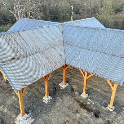 Custom Cardinal's Nest Pavilion (Options: 74' x 74', Douglas-fir, 20-Post Anchor Kit for High-Wind, 10' H Posts, Horizontal Decorative Trims for All Posts, with 5 Ceiling Fan Bases, Transparent Premium Sealant, White Wash for Ceiling). Photo Courtesy of J. Fookes of Elk Creek, CA.