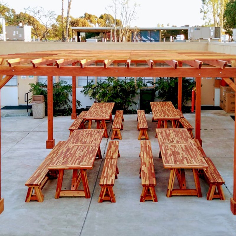 The Classic Redwood Patio Table (Options: 10' L x 36" W, Mosaic Reclaim Wood, Side Benches, 2 Half Length Benches Per Side, Old Country Tabletop, Standard, Slightly Rounded Corners, No Umbrella Hole, Transparent Premium Sealant). Photo Also Shows a Garden Pergola. Photo Courtesy of T. Sirvent. Tables Installed in Vanguard University, Costa Mesa, CA. The Classic Redwood Patio Table (Options: 10' L x 36" W, Mosaic Reclaim Wood, Side Benches, 2 Half Length Benches Per Side, Old Country Tabletop, Standard, Slightly Rounded Corners, No Umbrella Hole, Transparent Premium Sealant). Photo Also Shows a Garden Pergola. Photo Courtesy of T. Sirvent. Tables Installed in Vanguard University, Costa Mesa, CA.