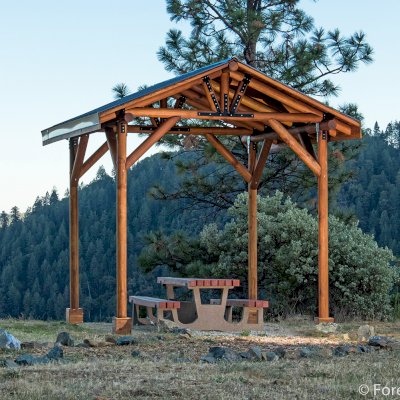Humboldt Log Pavilion (Options: 6in x 6in Posts Thickness, 12ft L x 12ft W, No Privacy Panels, California Redwood, 2 Fascia Boards for Gutters, 9.5ft Post Height, No Electrical Wiring Trim, 4-Post Anchor Kit for High-Wind, No Ceiling Fan Fan Bases, No Curtain Rods, Transparent Premium Sealant). Metal Roof Installed by Custom Request.