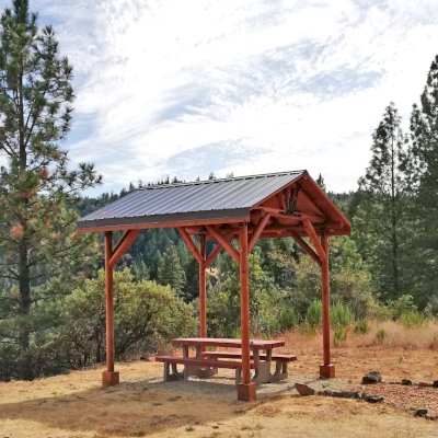 Humboldt Log Pavilion (Options: 6in x 6in Posts Thickness, 12ft L x 12ft W, No Privacy Panels, California Redwood, 2 Fascia Boards for Gutters, 9.5ft Post Height, No Electrical Wiring Trim, 4-Post Anchor Kit for High-Wind, No Ceiling Fan Fan Bases, No Curtain Rods, Transparent Premium Sealant). Metal Roof Installed by Custom Request.