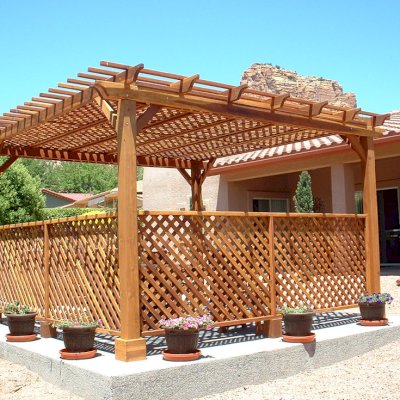 Lattice Pergola Kit (Options: 15' x 15', California Redwood, No Electrical Wiring Trim, 4-post Anchor Kit for Concrete, No Ceiling Fan Base, 2 Privacy Panels, No Curtain Rods, 9' Post Height, Transparent Premium Sealant). 2x2 Slats Above Rafters was Added as Custom Detail. It is not Part of Standard Design. Under the Pergola, a 7' San Francisco Patio Table Set with 42" W Tabletop, 4 Ruth Chairs and 2 Ruth Armchairs. Photo Courtesy of Mr. Joseph Dlugosz of Sedona, AZ.