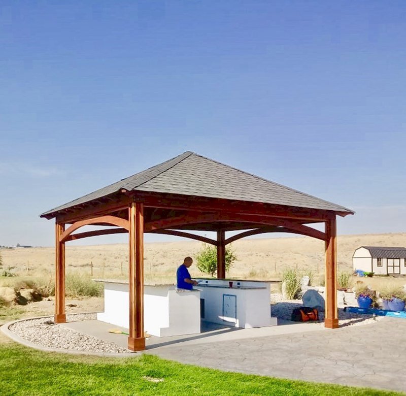 The Loreto Pavilion (Options: 18' L x 14' W, No Privacy Panels, California Redwood, 9' H, 2 Electrical Wiring Trims, 4-Post Anchor Kit for Concrete, Vertical Post Decorative Trims, 1 Ceiling Fan Base, No Curtain Rods, Transparent Premium Sealant). Photo Courtesy of S. Whitley of Moses Lake, Washington. The Loreto Pavilion (Options: 18' L x 14' W, No Privacy Panels, California Redwood, 9' H, 2 Electrical Wiring Trims, 4-Post Anchor Kit for Concrete, Vertical Post Decorative Trims, 1 Ceiling Fan Base, No Curtain Rods, Transparent Premium Sealant). Photo Courtesy of S. Whitley of Moses Lake, Washington.